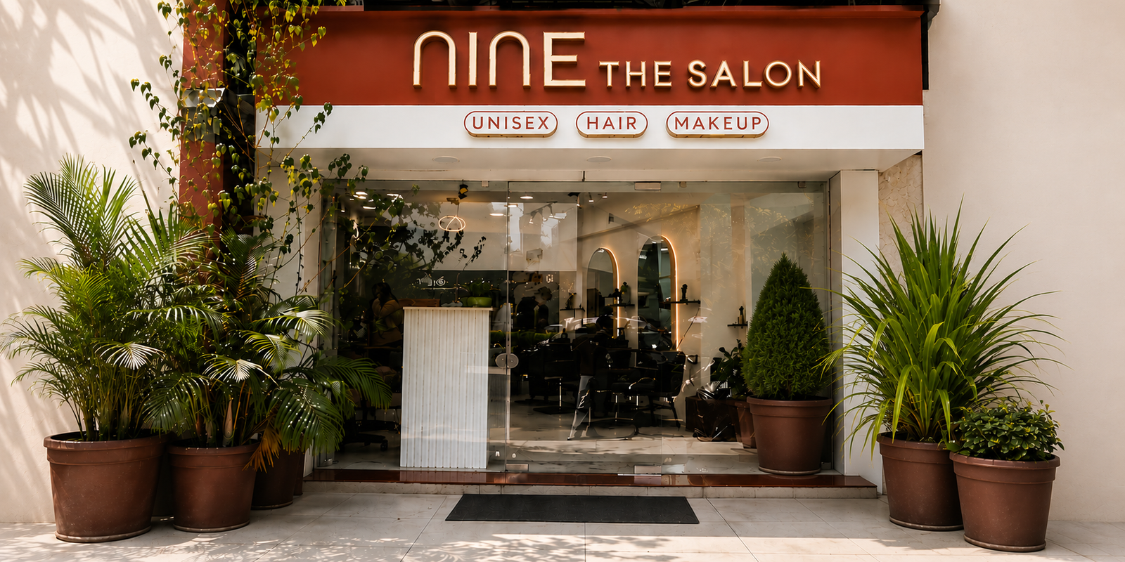 Nine The Salon storefront with lit signage and plants
